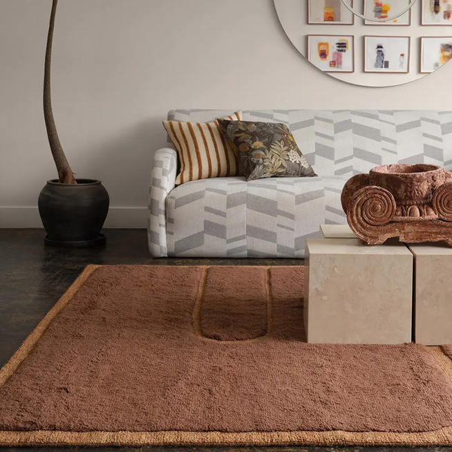 Modern living room with sculptural brown rug and geometric sofa – curved design trend 2026.